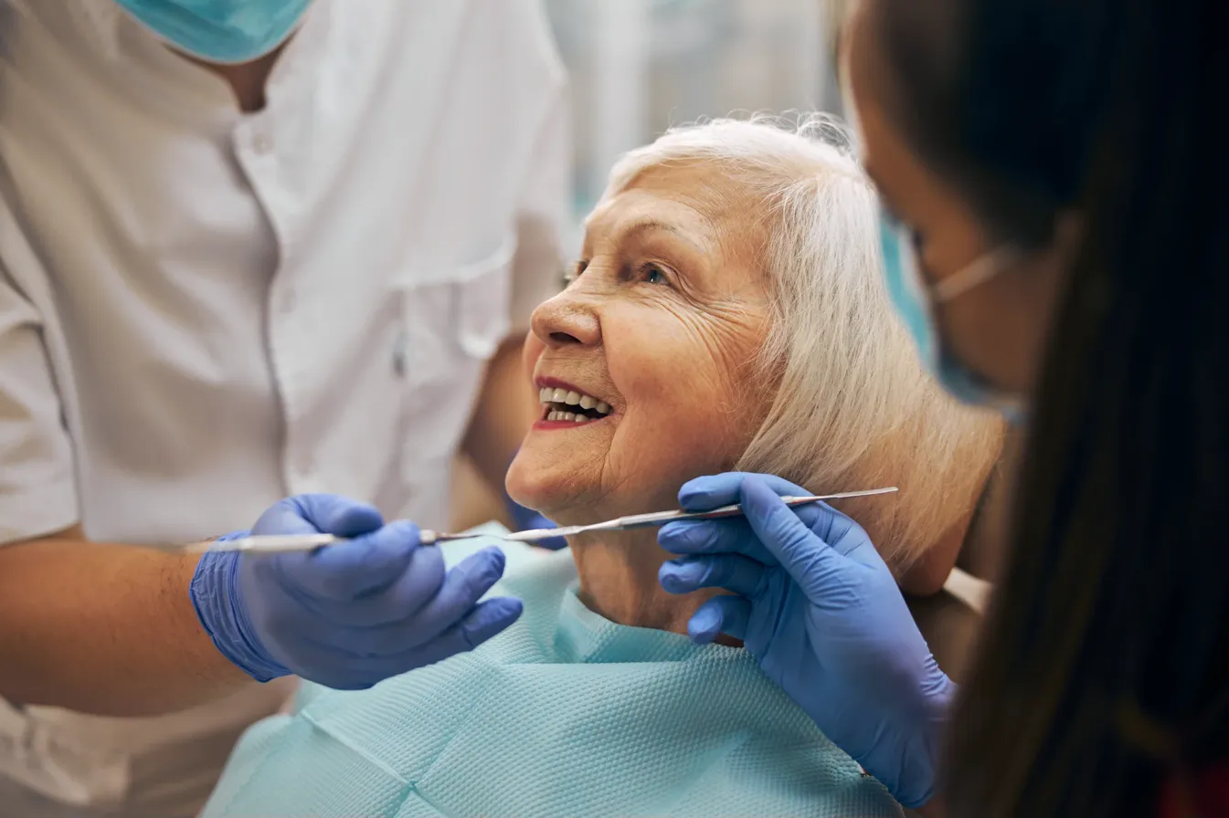 Senior woman smiling during professional dental cleaning procedure